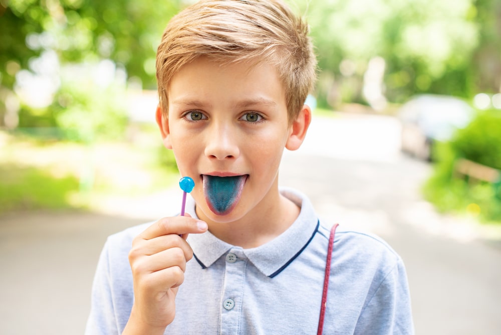 Teen,Blonde,Boy,Licking,Lollypops,And,Showing,Colored,Blue,Tongue.