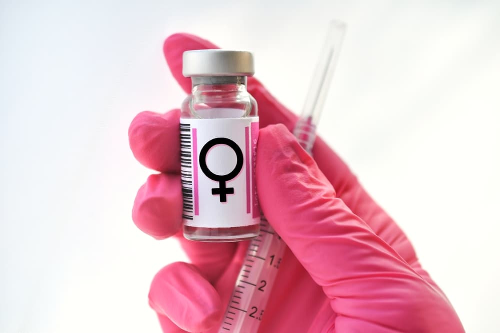 Pink,Gloved,Hand,Holding,A,Vial,With,Female,Symbol,,Hormones
